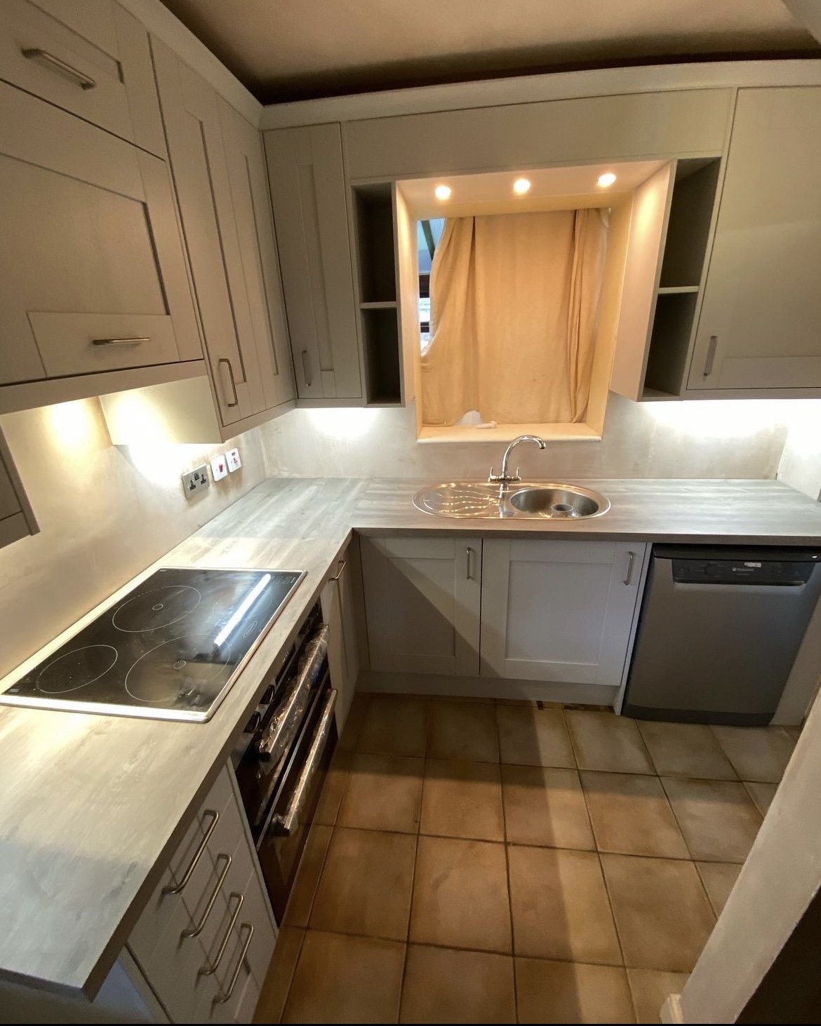 Grey shaker kitchen with under-cabinet lighting and a lit canopy over the sink
