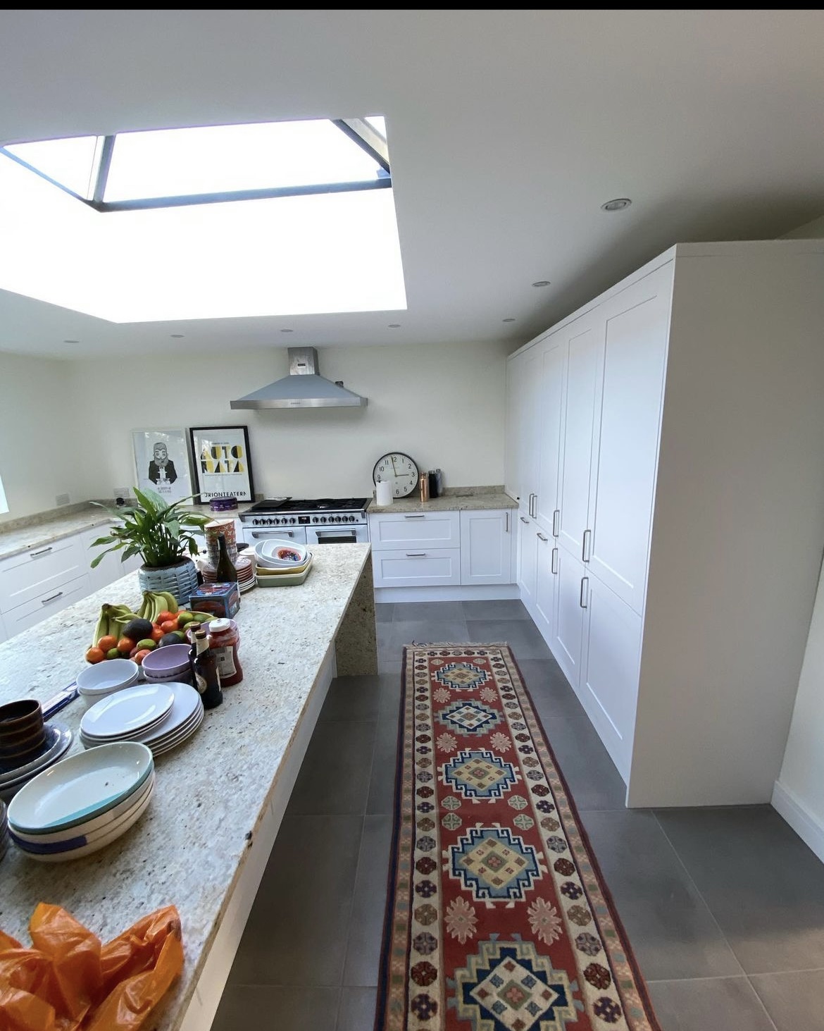 White kitchen with a long island under a roof lantern