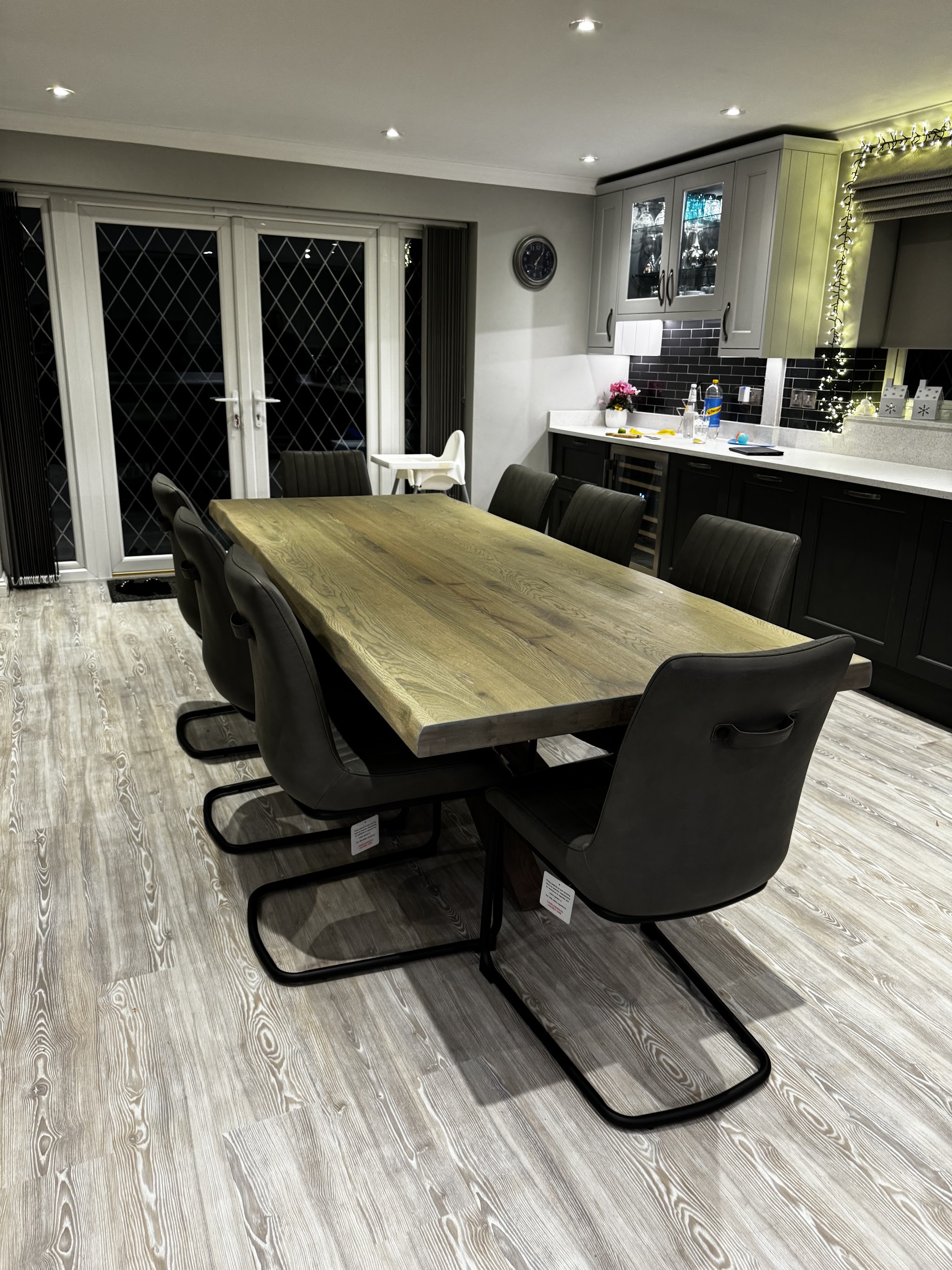 Open-plan dining area with the new dark kitchen units behind