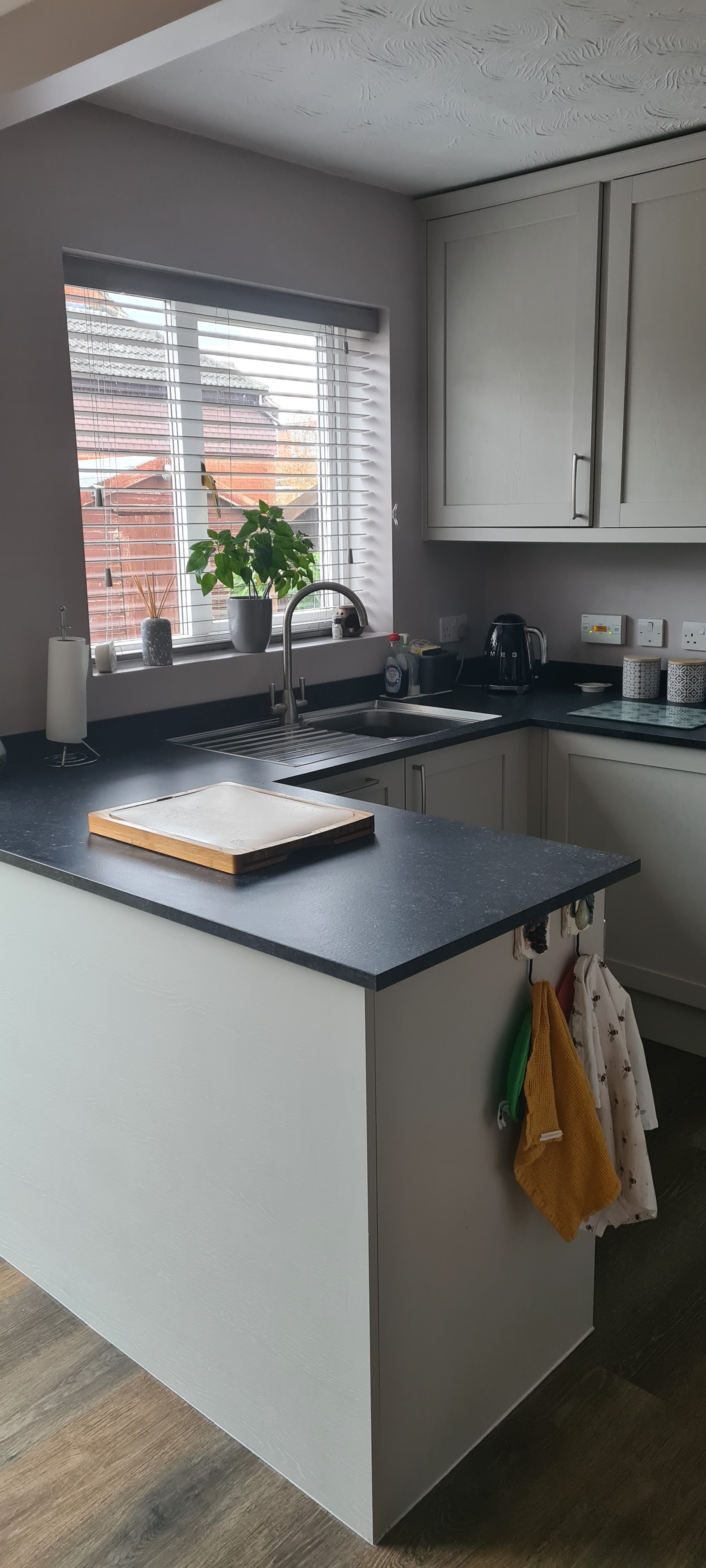 Grey shaker kitchen with a dark worktop and peninsula