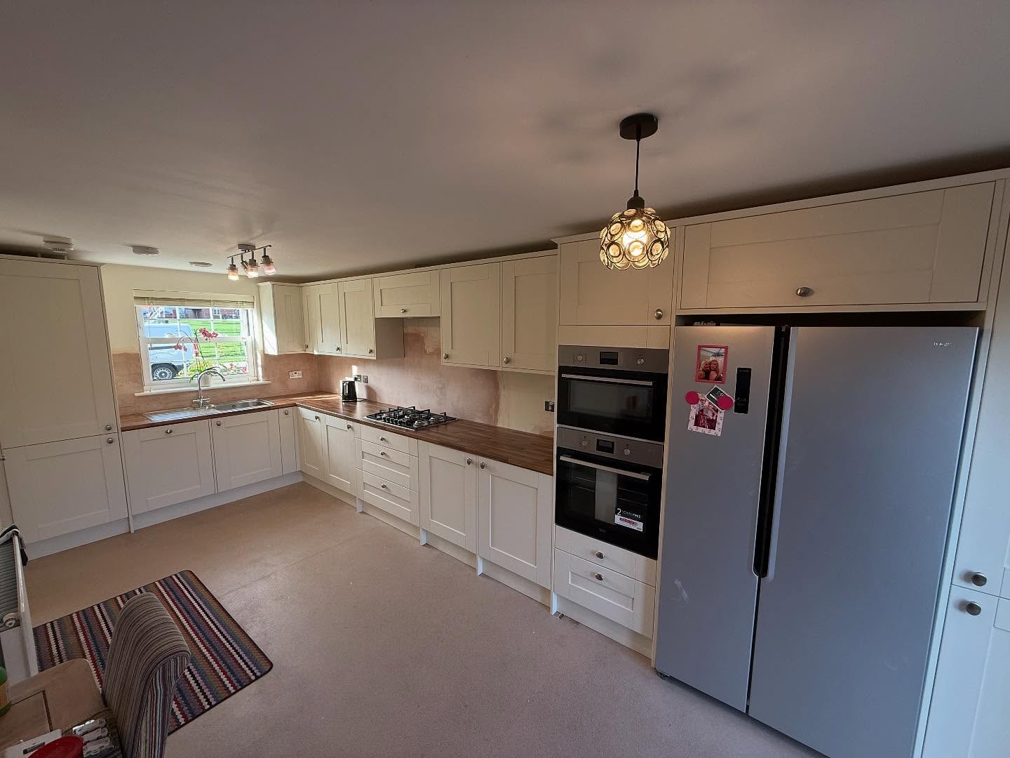 Cream shaker Wickes kitchen with an American fridge freezer and double oven